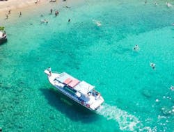 The boat on the turquoise waters during the Glass-Bottom Boat Trip around Lindos Coast with Swimming at the Red Sand Beach from Lindos Glas Bottom Cruise Melani.