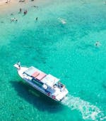 El barco en las aguas turquesas durante el viaje en barco con fondo de cristal alrededor de la costa de Lindos con la natación en la playa de arena roja de Lindos Glas Bottom Cruise Melani.