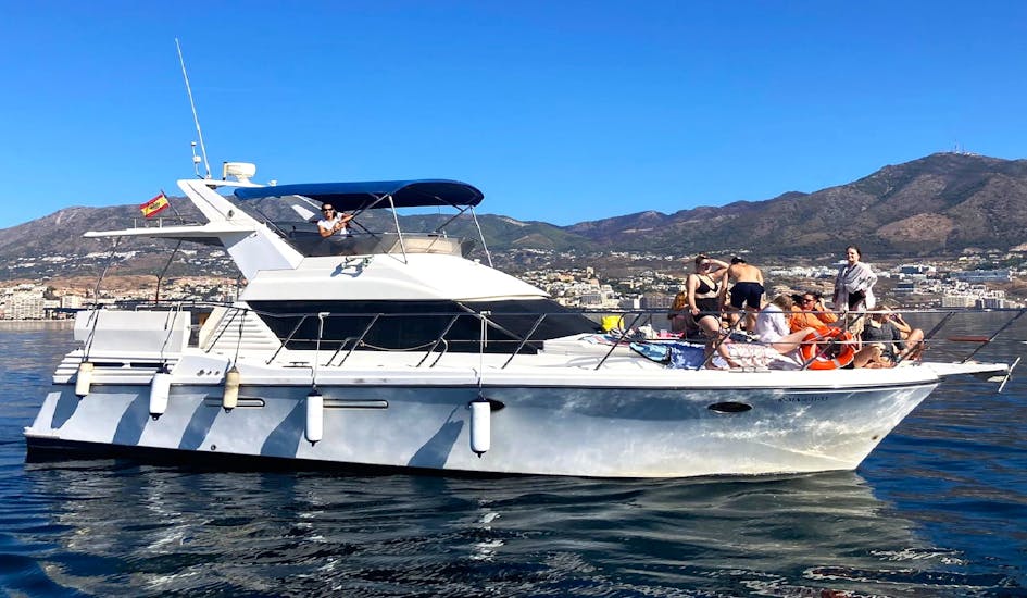 Alcune persone stanno cercando di avvistare dei delfini durante il Giro in yacht privato nella Costa del Sol con avvistamento delfini, drink e snack.