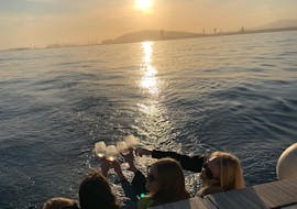 I partecipanti fanno un brindisi durante ilGiro in barca a vela al tramonto da Barcellona con sosta per nuotare con SeaBarcelona - Sailing Balearic.
