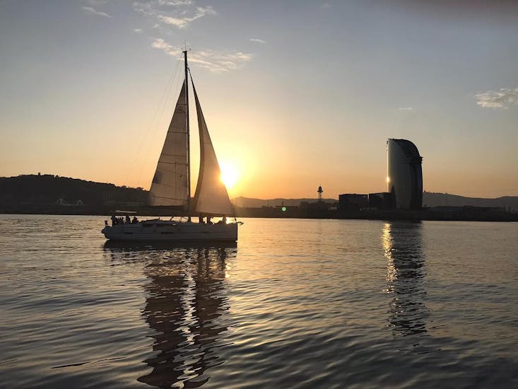 Vista della barca illuminata dal tramonto durante il Giro in barca a vela al tramonto da Barcellona con sosta per nuotare con SeaBarcelona - Sailing Balearic.