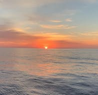 El sol se pone durante el viaje en yate al atardecer desde Palma de Mallorca con barra libre, SUP y snorkel con SeaBarcelona - Sailing Balearic.