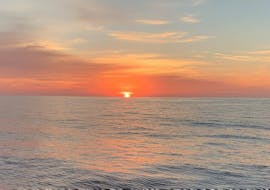 El sol se pone durante el viaje en yate al atardecer desde Palma de Mallorca con barra libre, SUP y snorkel con SeaBarcelona - Sailing Balearic.