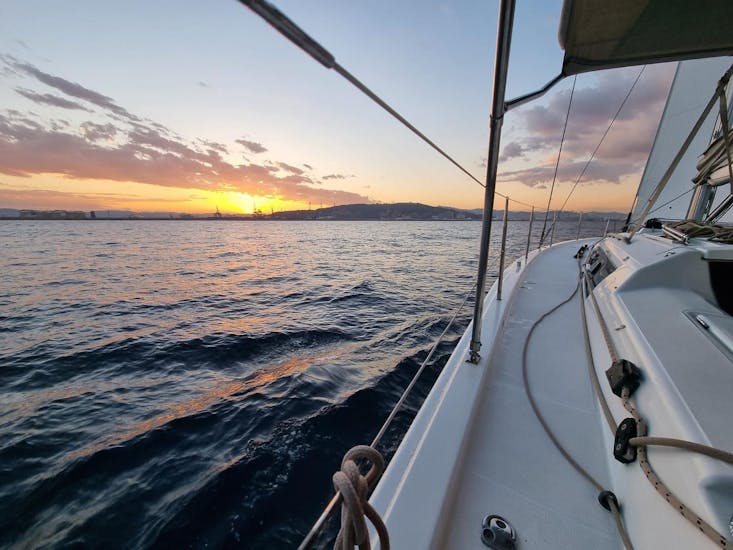The sailboat is navigating under the sunset during the Sunset Yacht Trip from Palma de Mallorca with Open Bar, SUP & Snorkeling with SeaBarcelona - Sailing Balearic.