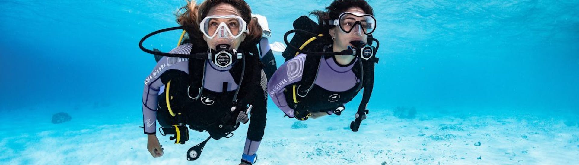 Two women dive during the PADI Open Water Course in Sliema for Beginners with Dive Systems Malta.