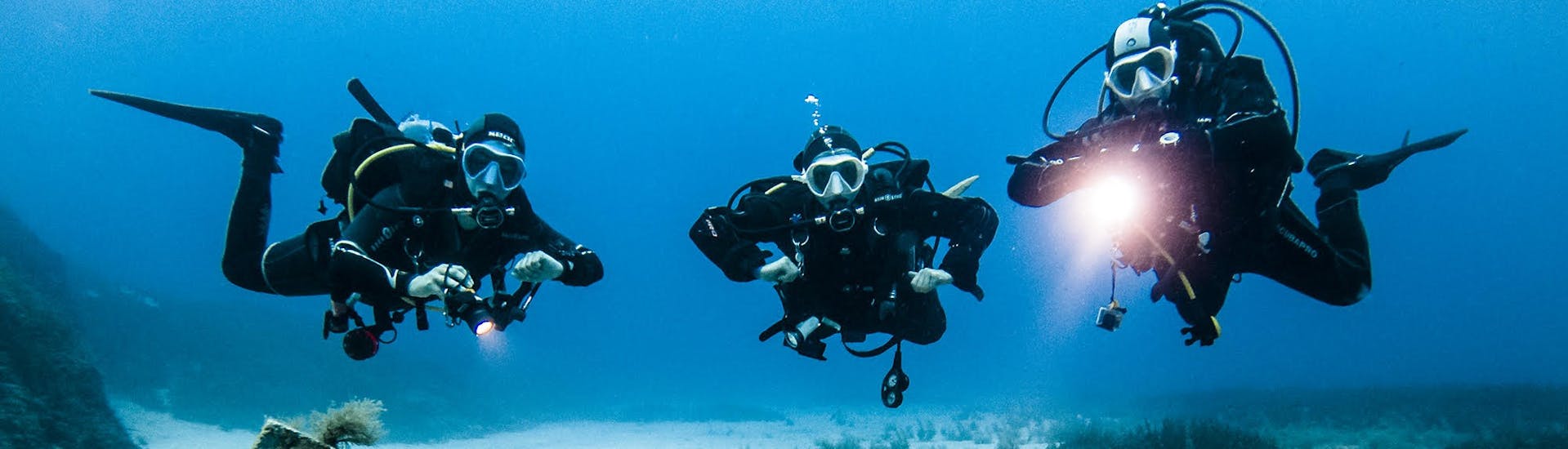 Alcuni subacquei esplorano il fondale marino durante le Immersioni di prova per principianti a Sliema con Malta Blue Diving.