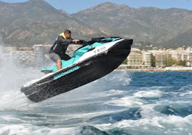 A boy doing jumps with a jet ski during a Jet Ski from Marbella along Costa del Sol from Marbella Renting Boat.
