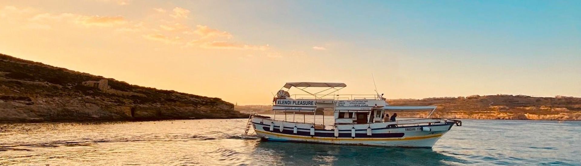 Personen machen eine Bootstour bei Sonnenuntergang von Gozo zur Blauen Lagune und zu den Höhlen von Comino mit Xlendi Pleasure Cruises