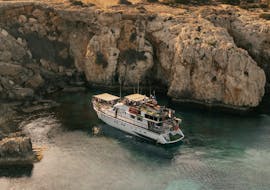 Boat in front of caves, used for the Trip from Protaras to Blue Lagoon with BBQ - Adults Only with The Cyprus Cruise Company.