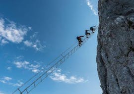 A group of people climbing up the spectacular sky ladder of the Via Ferrata for the Brave on the Donnerkogel with the experienced guides from Bergführer Salzburg.