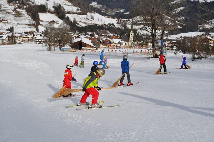 Een kind en een instructeur oefenen tijdens hun skilessen voor kinderen voor gevorderden bij skischool Aktiv in Wildschönau.