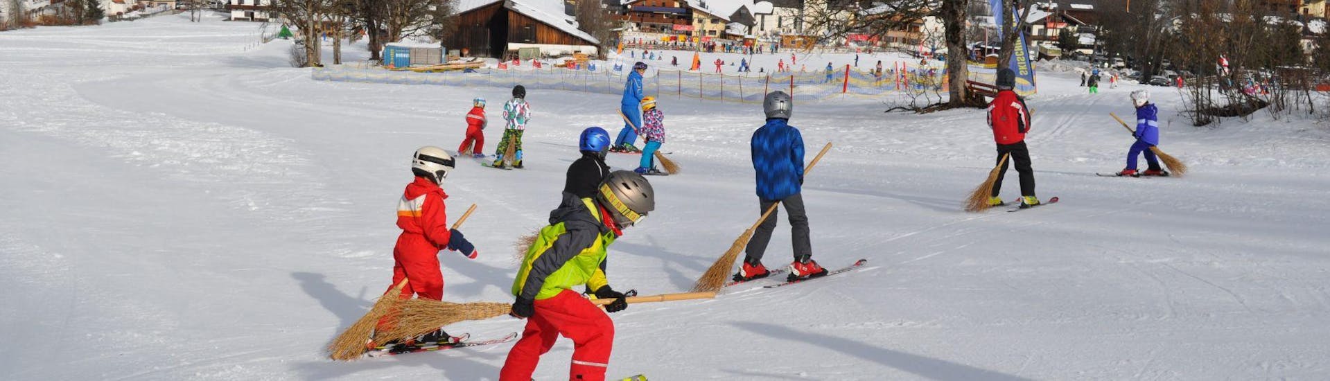 Kinder fahren Ski beim Kinder-Skikurs (6-15 J.) für Fortgeschrittene (halbtägig).