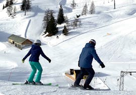 Two adults enjoying the slope at their Adult Ski Lessons for Skiers with Experience from Gipfelmomente Tauplitz.