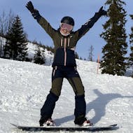 Eine Snowboarderin jubelt beim Snowboardkurs für Kinder & Erwachsene (ab 4 J.) für Anfänger mit Gipfelmomente Tauplitz.