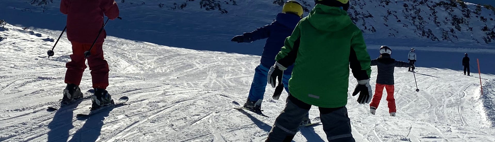 A group of kids skiing at their Private Ski Lessons for Kids (4-15 y.) for All Levels.