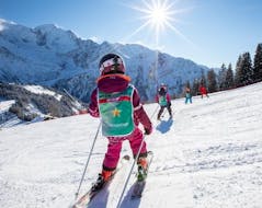 A kids is getting down the slope during Kids Ski Lessons (6-12 y.) of All Levels from ESF Les Houches.