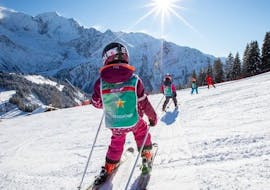 A kids is getting down the slope during Kids Ski Lessons (6-12 y.) of All Levels from ESF Les Houches.
