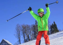 A kid is cheering during his Kids Ski Lessons (6-10 y.) for Advanced Skiers from Skischool Hochharz.