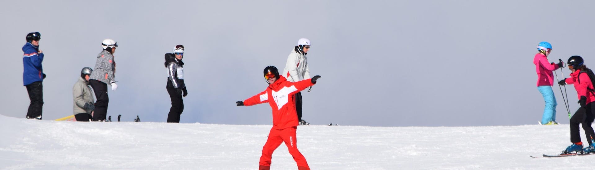 Ein Skilehrer und eine Gruppe Erwachsener beim Skikurs für Erwachsene (ab 15 J.) für Fortgeschrittene - Auffrischkurs mit Skischule Snowsports Westendorf.