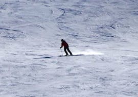 Ein Erwachsener auf einer weiten, weißen Piste beim Skikurs für Erwachsene für alle Levels mit Skiverleih Schneider Events Geißkopf.