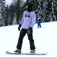 A snowboarder during his Private Snowboarding Lessons (from 4 y.) of All Levels from Skischule Schneider Events Geißkopf.