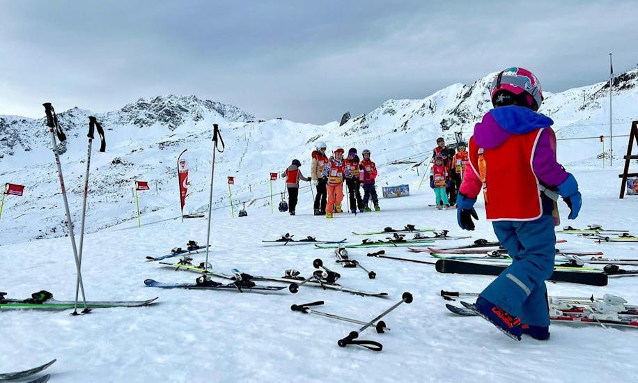 Kinder machen eine Pause während dem Kinder-Skikurs (4-17 J.) für Anfänger.