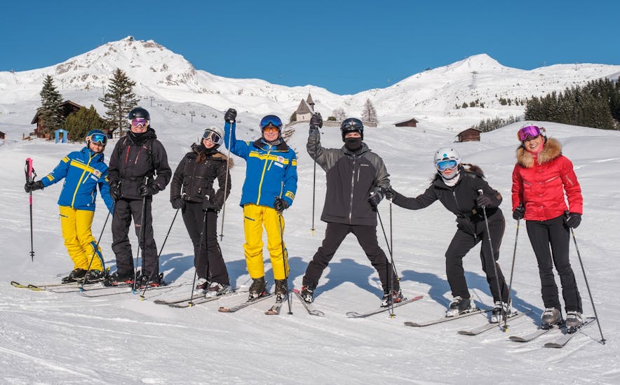 Eine Gruppe Erwachsener jubeln während dem Skikurs für Erwachsene für alle Levels.