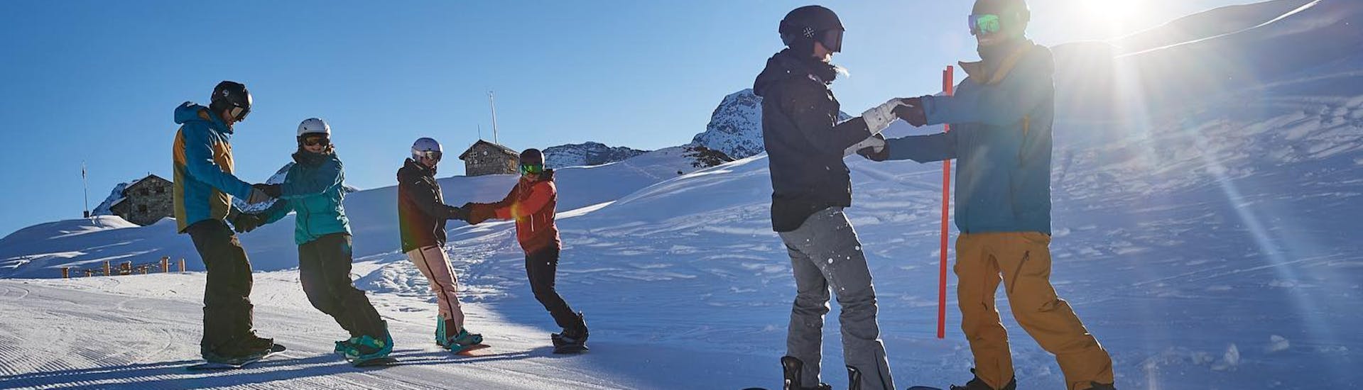 Schüler üben gemeinsam während dem Snowboardkurs für Kinder (ab 7 J.) & Erwachsene für Fortgeschrittene.