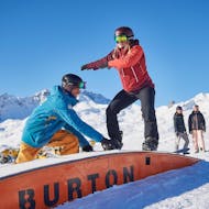 Ein Snowboardlehrer und eine Schülerin üben während dem Snowboardkurs für Kinder (ab 7 J.) & Erwachsene für Fortgeschrittene mit Schweizer Ski- und Snowboardschule Arosa.