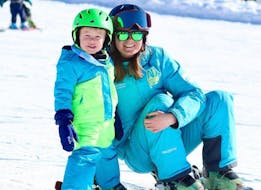 A young skier is very happy to be with his instructor during a private ski lesson for kids with Adrenaline Verbier.