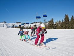 Zwei Kinder geben sich ein High-Five während dem Kinder-Skikurs (5-12 J.) für Anfänger mit Skischule Snowacademy Saalbach.