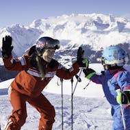 A ski instructor and a kid having fun during the Kids Ski Lessons (3-13 y.) for Beginners from Official Swiss Ski School Rougemont Gstaad.