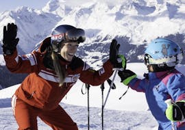 Eine Skilehrerin und ein Kind haben Spaß während dem Kinder-Skikurs (3-13 J.) für Anfänger mit Official Swiss Ski School Rougemont Gstaad.