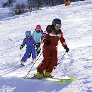 A ski instructor and two little skiers during the Kids Ski Lessons (3-13 y.) for Advanced Skiers from Official Swiss Ski School Rougemont Gstaad.