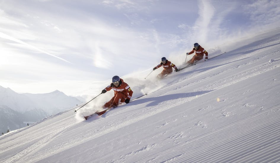 Three skiers enjoying a descent during the Private Ski Lessons for Adults of All Levels.