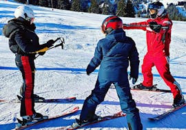 A ski instructor and two students during their Private Ski Lessons for Kids (from 3 y.) of All Levels from Official Swiss Ski School Rougemont Gstaad.
