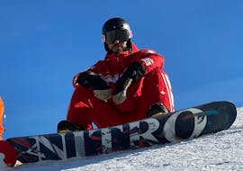 A snowboarder sitting in the snow during the Private Snowboarding Lessons for Kids (from 3 y.) & Adults of All Levels from Official Swiss Ski School Rougemont Gstaad.