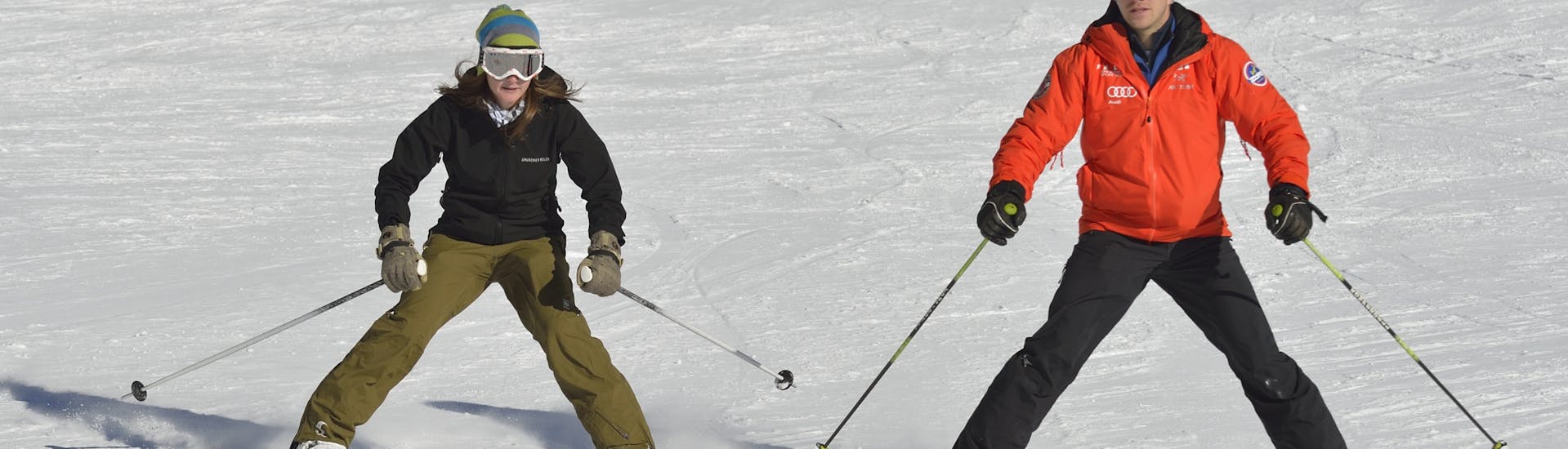 Ein Skianfänger und ein Skilehrer während dem Skikurs für Erwachsene Anfänger.