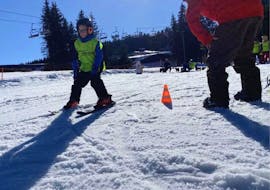 A kid and an instructor on the snow during the Private Ski Lessons for Kids (from 5 y.) of All Levels from Ski school & Rental Sportwelt Oberhof.