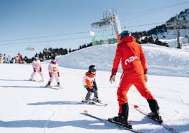 Image d'un moniteur de Neige Aventure enseignant le ski à un groupe d'nfants.