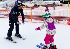 A kid and an instructor during the Kids Ski Lessons (6-12 y.) for First Timers from Ski School Feldberg Sports.