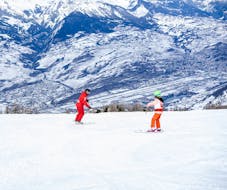 Image d'un moniteur de Neige Aventure enseignant le ski à un enfant pendant un cours particulier de Neige Aventure.
