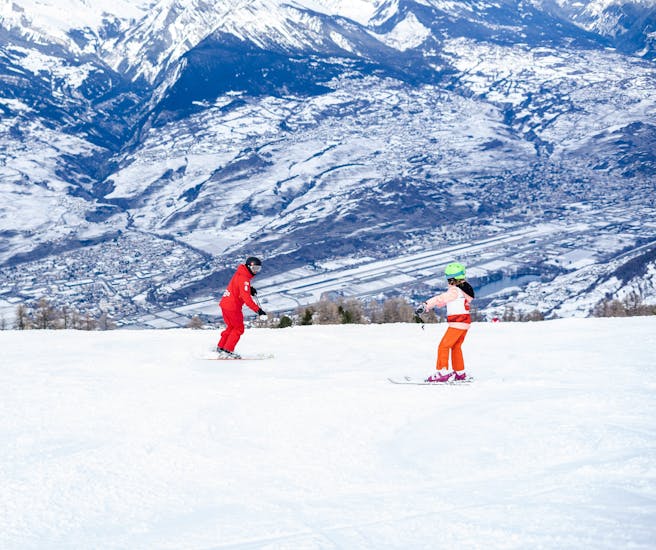 Picture of a Neige Aventure instructor teaching a child how to ski.