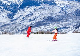 Image d'un moniteur de Neige Aventure enseignant le ski à un enfant pendant un cours particulier de Neige Aventure.
