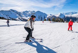 Image d'un moniteur enseignant le ski à une femme pendant un cours privé pour adultes de tous niveaux avec Neige Aventure.