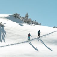 Zwei Teilnehmer genießen einen sonnigen Tag im Schnee während ihrer Privaten Skitour für alle Levels mit Hansi Kienle.