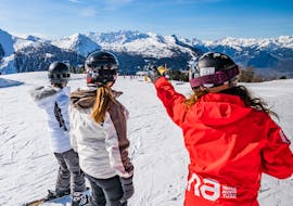 Bild eines Lehrers von Neige Aventure, der vier Teenagern das Skifahren beibringt.