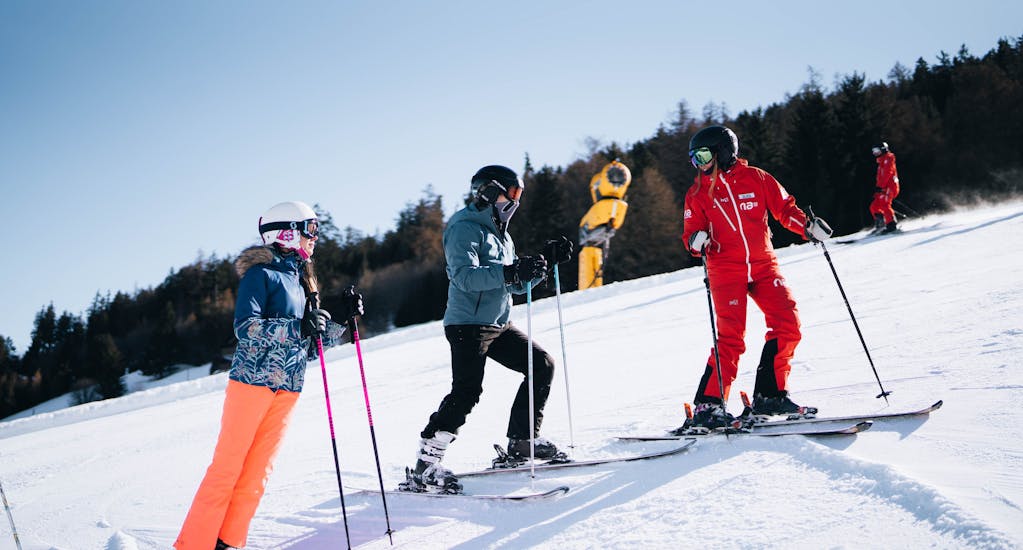Image of two friends with their instructor during a ski lesson for teens and adults with Neige Aventure.