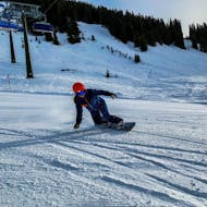 A snowboarder boarding down the slopes of Kaprun during the Private Snowboarding Lessons for Kids & Adults of All Levels from Ski School Bruck Fusch.