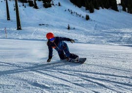 A snowboarder boarding down the slopes of Kaprun during the Private Snowboarding Lessons for Kids & Adults of All Levels from Ski School Bruck Fusch.